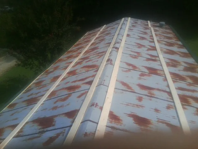 Rusted metal roof panels with new wood purlins before replacement — Storm Damage Roof Repair in Flatonia by Roofing Brothers