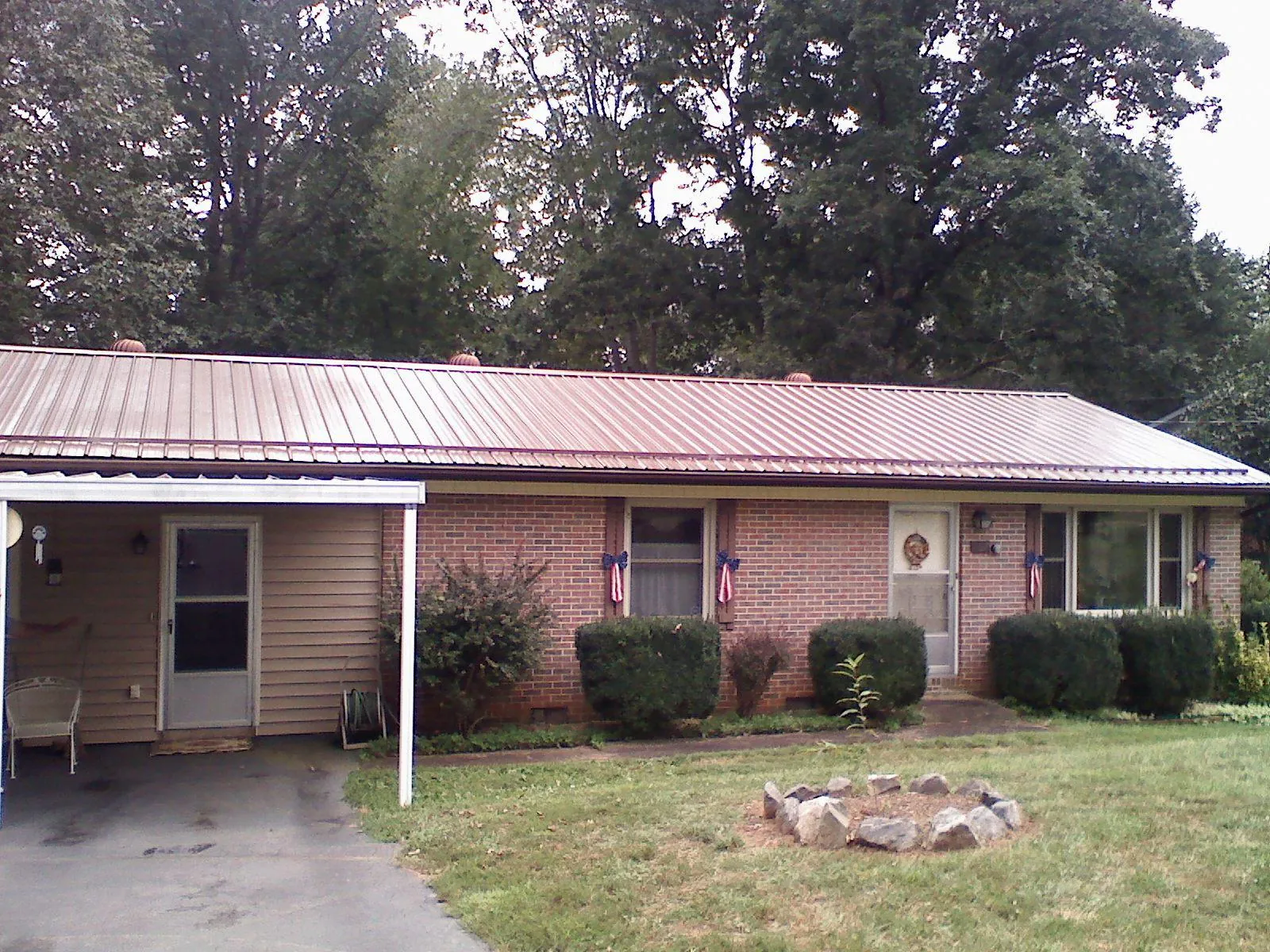 Bronze metal roof and carport on a brick ranch home — Roof Repair work by our crew in Flatonia