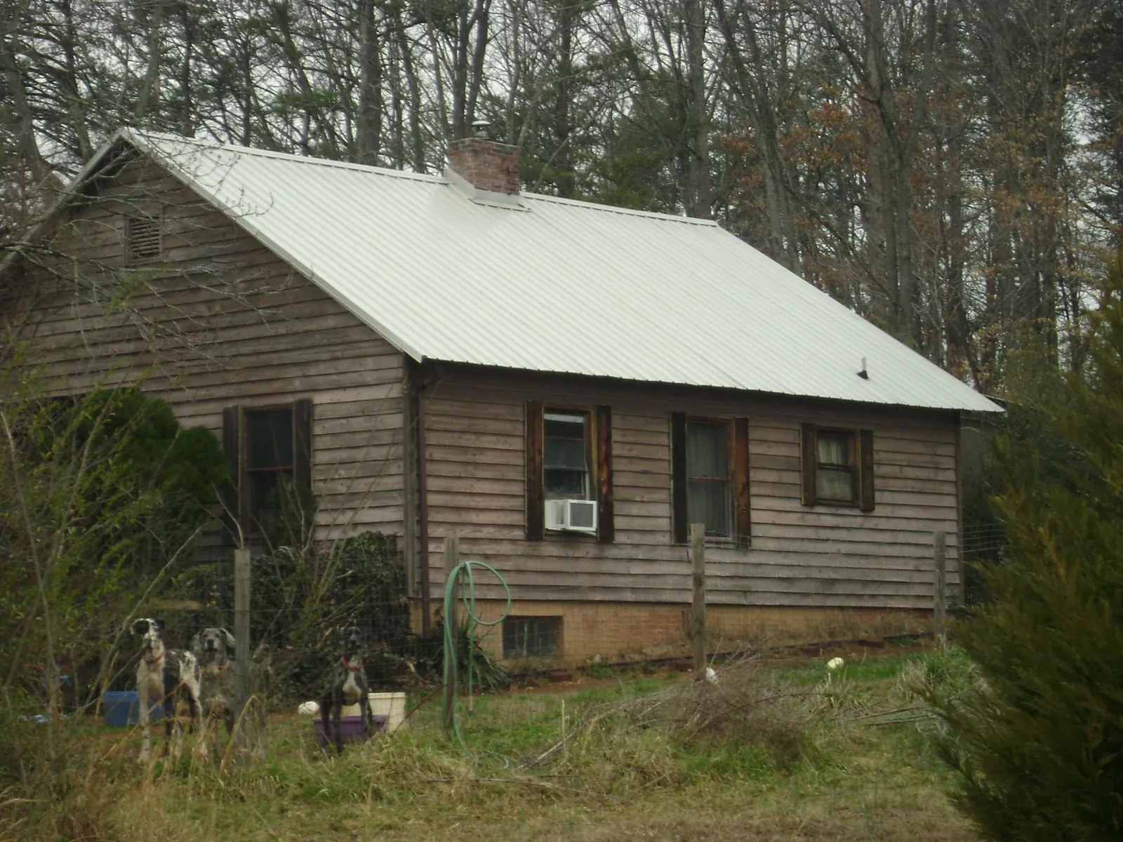 White metal roof on an old wood sided farmhouse, from a Metal Roof Installation job in Flatonia
